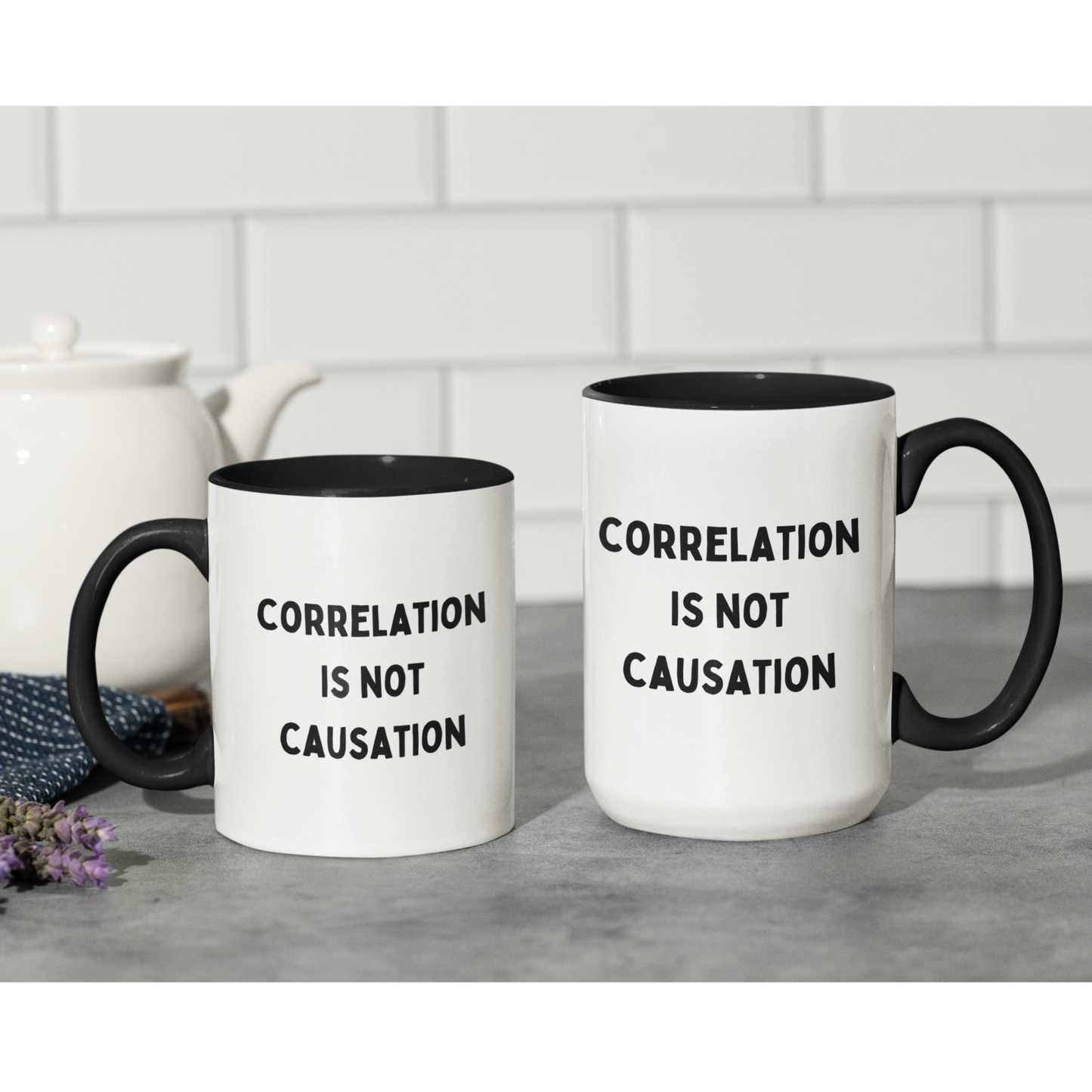 11 & 15 oz ceramic coffee mug featuring a bold and minimalist design. The mug has a white glossy finish with a contrasting black handle and black interior. On the front, it displays the phrase "CORRELATION IS NOT CAUSATION" in all-caps, black, sans-serif font, centered across three lines.