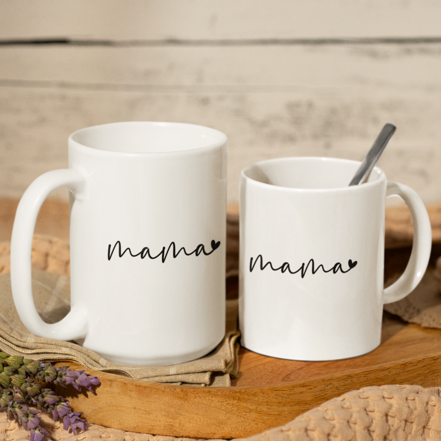 Sleek 11 & 15 oz white ceramic coffee mug featuring a minimalist black handwritten-style script that reads “mama” with a small heart accent at the end. The mug has a smooth, glossy finish and a large, easy-grip handle. Perfect for gifting to moms who appreciate simple, modern design and a daily reminder of their cherished role. Ideal for Mother’s Day, birthdays, or everyday appreciation.