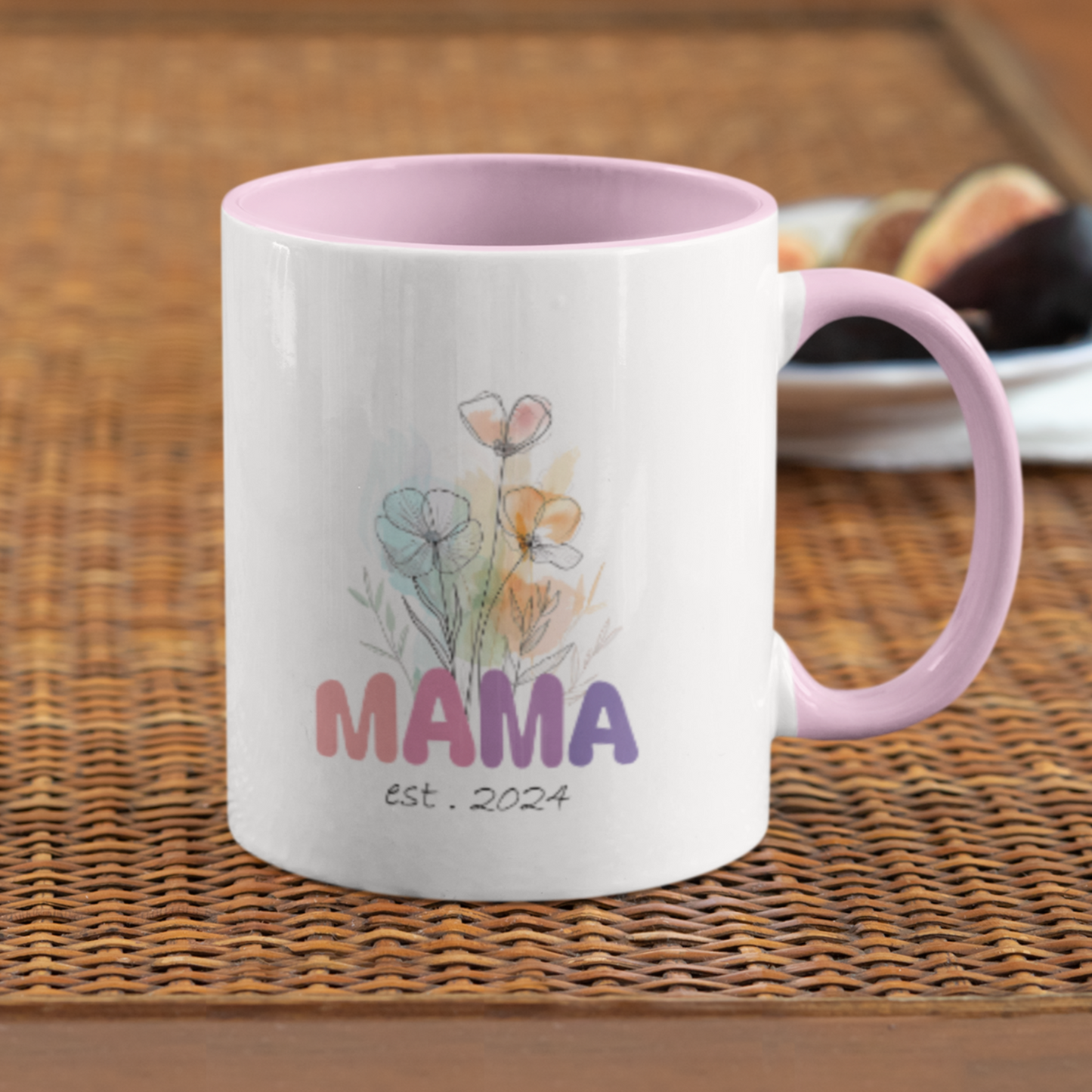 Adorable 11 oz white ceramic coffee mug with a glossy finish, featuring a soft pink interior and matching pink handle. The design showcases a delicate watercolor floral bouquet above the word “MAMA” in cheerful gradient tones from pink to purple, with the text “est. 2024” in a stylish handwritten script below. This mug is a perfect gift for new moms celebrating their first Mother's Day or a sweet keepsake marking the beginning of their motherhood journey.
