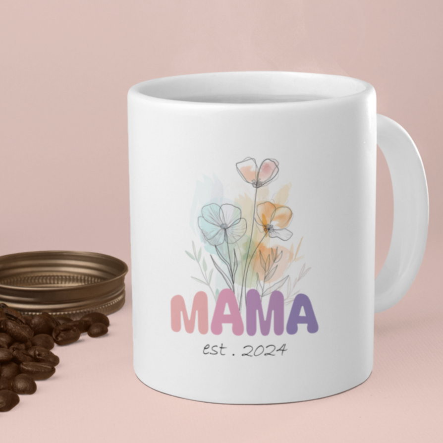 Charming 11 oz white ceramic mug featuring a soft watercolor-style floral bouquet and the word “MAMA” in bold, colorful letters transitioning from pink to purple. Beneath the floral artwork, the text reads “est. 2024” in a delicate handwritten font. Perfect gift for new moms or a Mother’s Day surprise celebrating motherhood’s newest chapter.