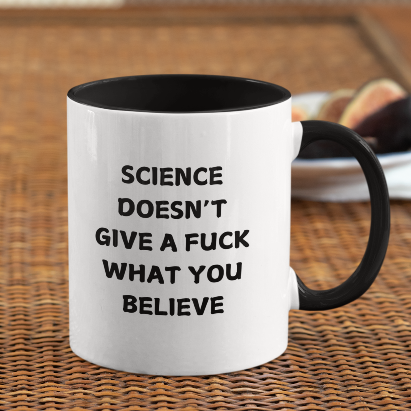 11 oz bold and edgy ceramic coffee mug designed for science enthusiasts and skeptics alike. The mug features a sleek black interior and handle, contrasting with its clean white exterior. Printed in bold, all-caps black lettering on one side is the unapologetic statement: "SCIENCE DOESN'T GIVE A F*** WHAT YOU BELIEVE."