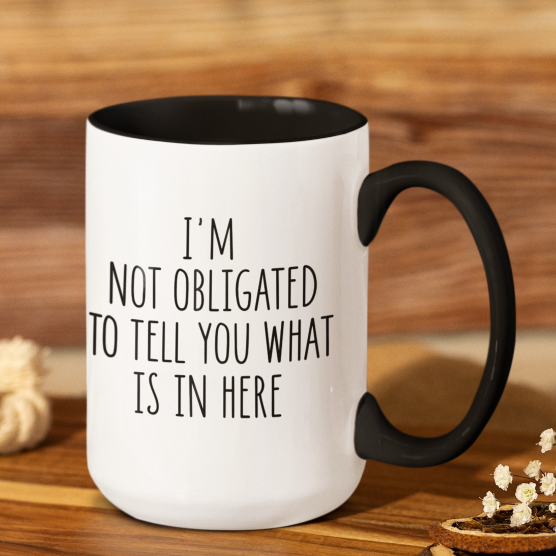 Simple yet impactful 15 oz white mug with black accents, featuring the witty statement "I'M NOT OBLIGATED TO TELL YOU WHAT IS IN HERE" in a clear black font. Perfect for those with a dry wit and a desire for a little beverage privacy.