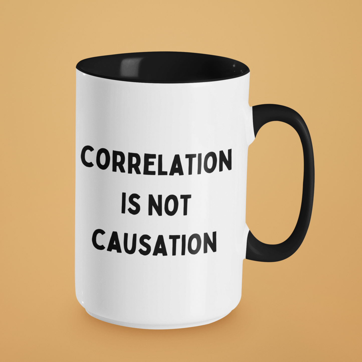15 oz ceramic coffee mug featuring a bold and minimalist design. The mug has a white glossy finish with a contrasting black handle and black interior. On the front, it displays the phrase "CORRELATION IS NOT CAUSATION" in all-caps, black, sans-serif font, centered across three lines.