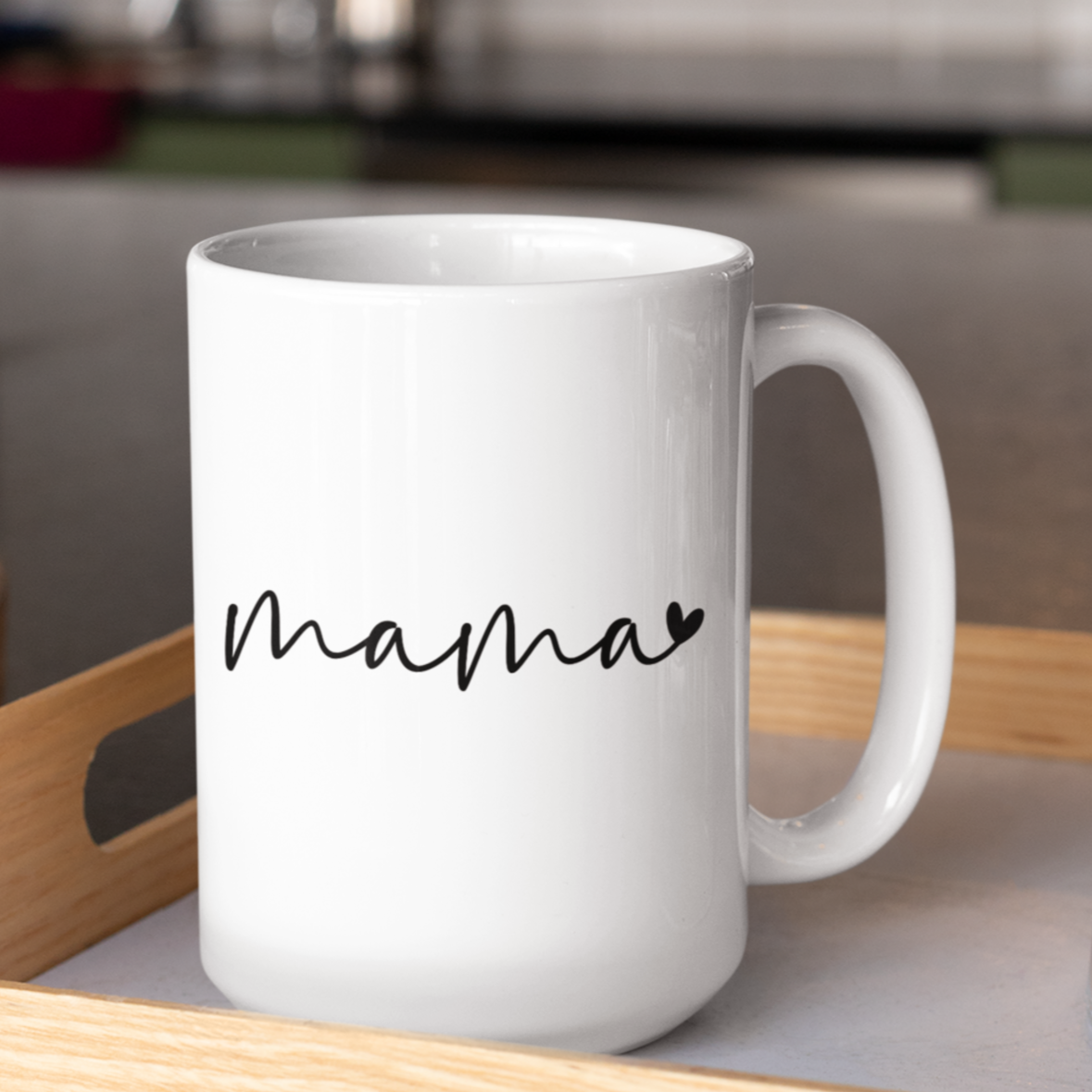 Sleek 15 oz white ceramic coffee mug featuring a minimalist black handwritten-style script that reads “mama” with a small heart accent at the end. The mug has a smooth, glossy finish and a large, easy-grip handle. Perfect for gifting to moms who appreciate simple, modern design and a daily reminder of their cherished role. Ideal for Mother’s Day, birthdays, or everyday appreciation.