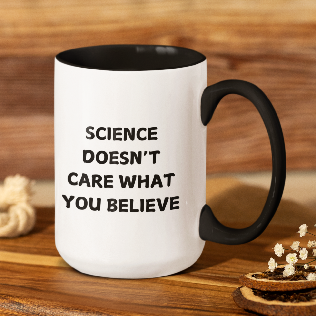 15 oz stylish ceramic coffee mug with a bold black handle and matching black interior, creating a sleek contrast against its glossy white exterior. The front of the mug features a powerful statement in all-capital black letters: "SCIENCE DOESN'T CARE WHAT YOU BELIEVE." The font is clean and impactful, making the message stand out.