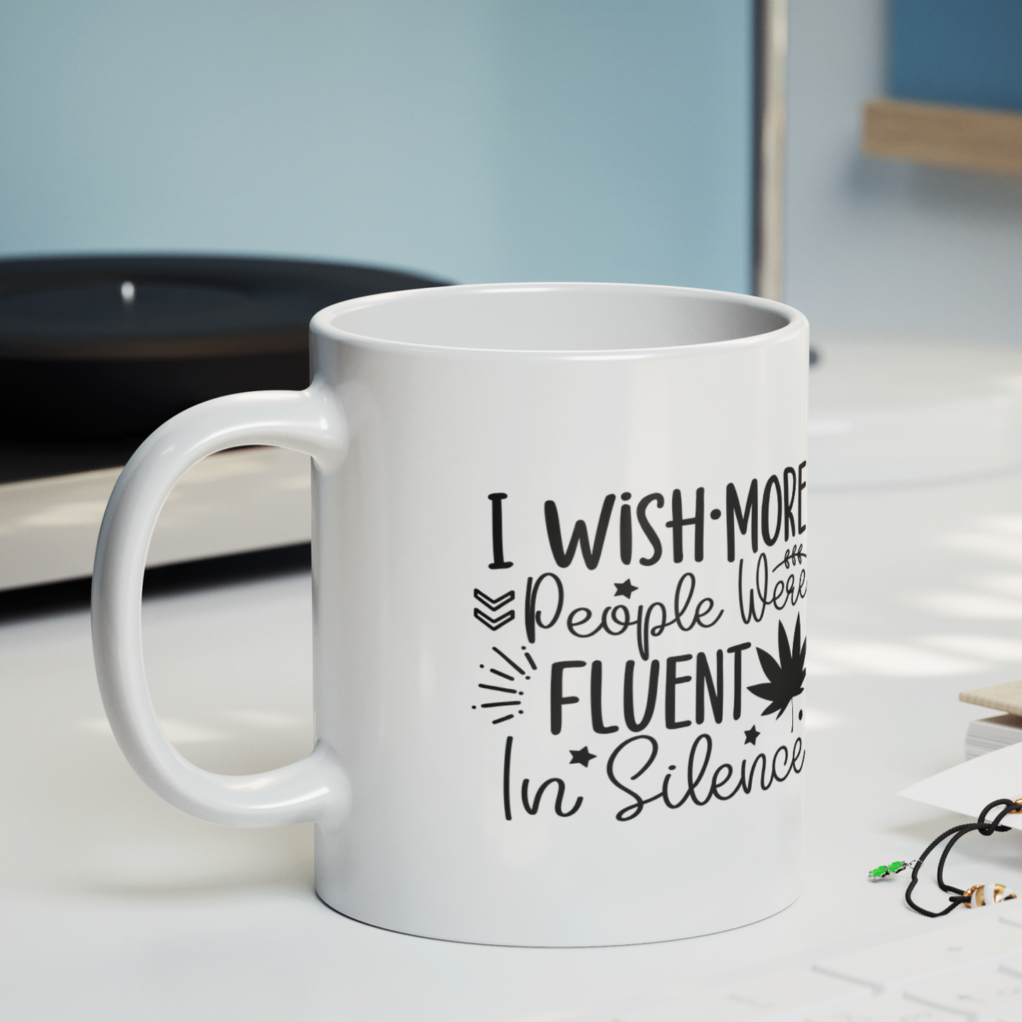Stylish white ceramic mug with a sassy black text design that reads, “I wish more people were fluent in silence,” accented with playful stars, leaves, and a bold graphic of a maple leaf. Minimalist aesthetic—perfect for introverts, deep thinkers, or anyone who values peace and quiet. Durable, dishwasher-safe, and great for gifting or personal use with hot beverages like coffee or tea.