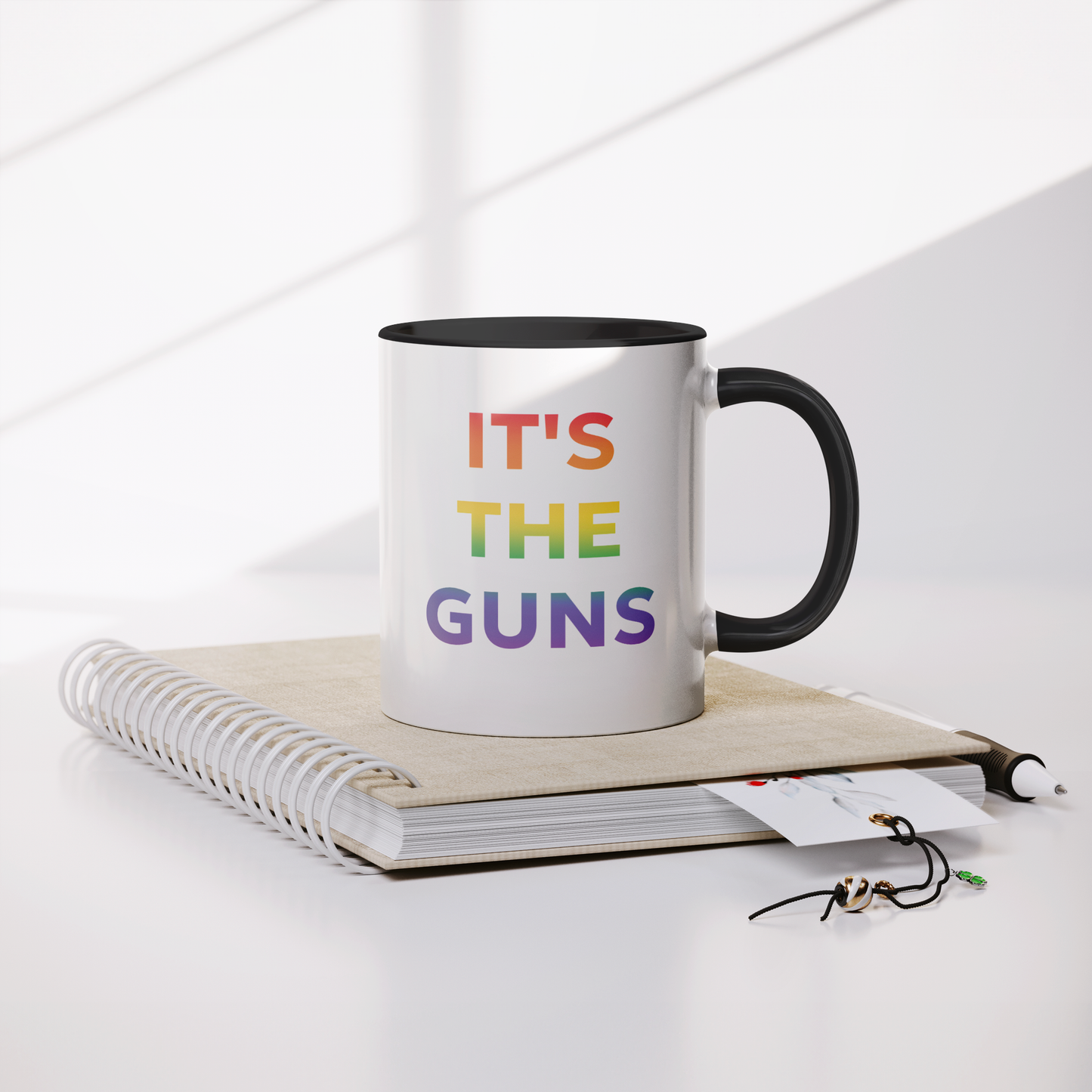 Its_The_Guns_Coffee_Mug_Supporting_Gun__Mug_Lifestyle_Notebook_Mockup.png