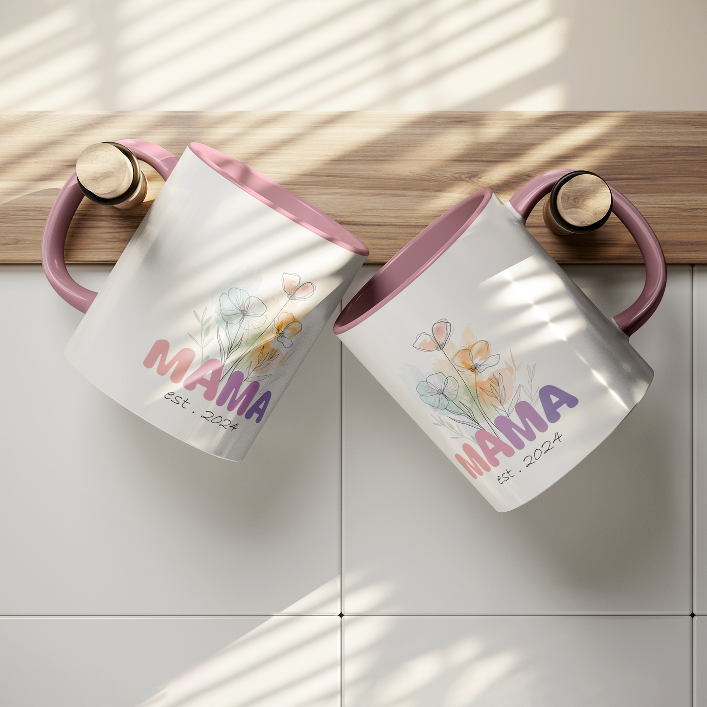 Adorable 11 oz white ceramic coffee mug with a glossy finish, featuring a soft pink interior and matching pink handle. The design showcases a delicate watercolor floral bouquet above the word “MAMA” in cheerful gradient tones from pink to purple, with the text “est. 2024” in a stylish handwritten script below. This mug is a perfect gift for new moms celebrating their first Mother's Day or a sweet keepsake marking the beginning of their motherhood journey.
