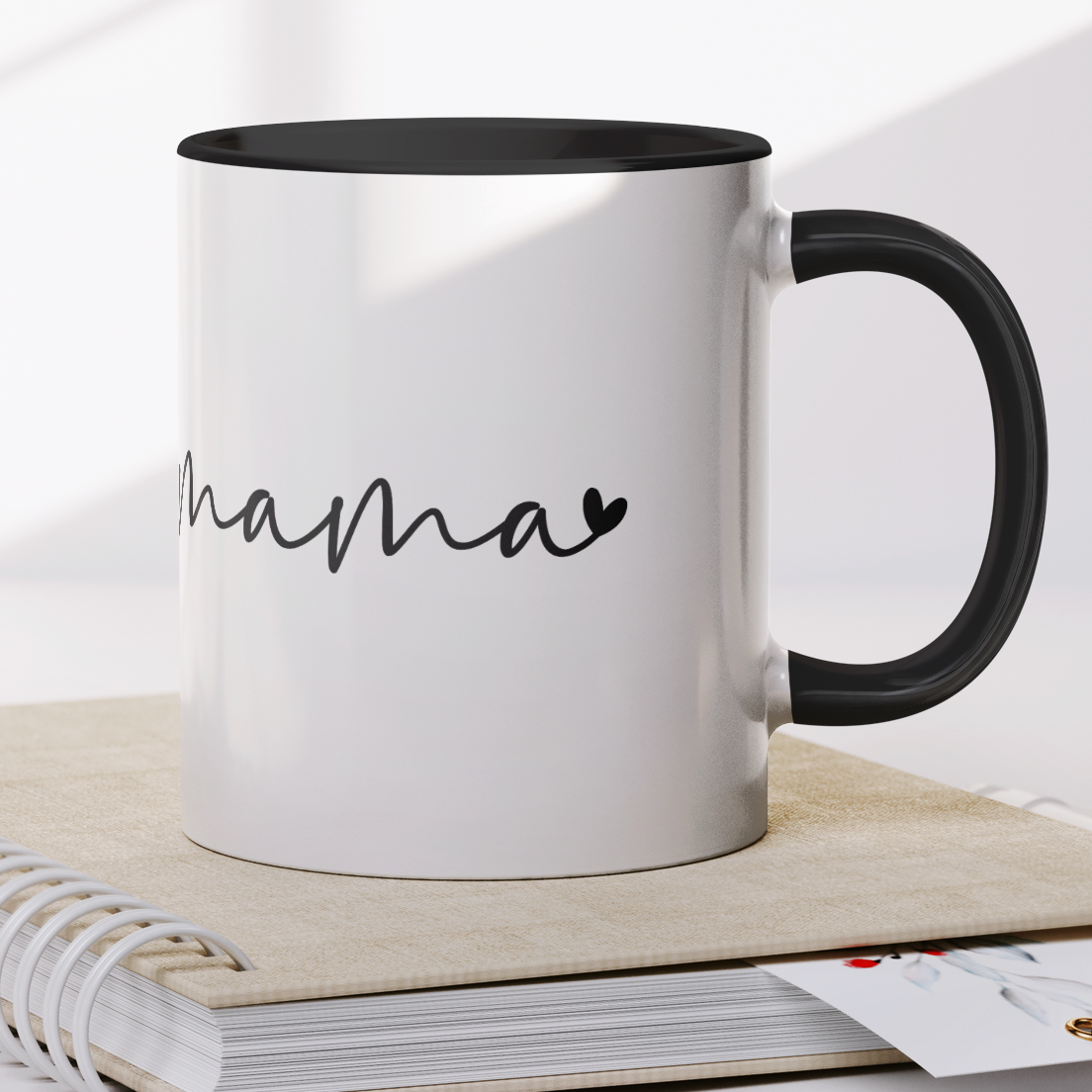 Modern 11 oz white ceramic mug with a sleek black interior and matching black handle, featuring elegant handwritten-style text that says “mama” with a small heart accent. Perfect for gifting to stylish moms who appreciate minimalistic design with a heartfelt touch — ideal for Mother’s Day, birthdays, or everyday coffee moments.