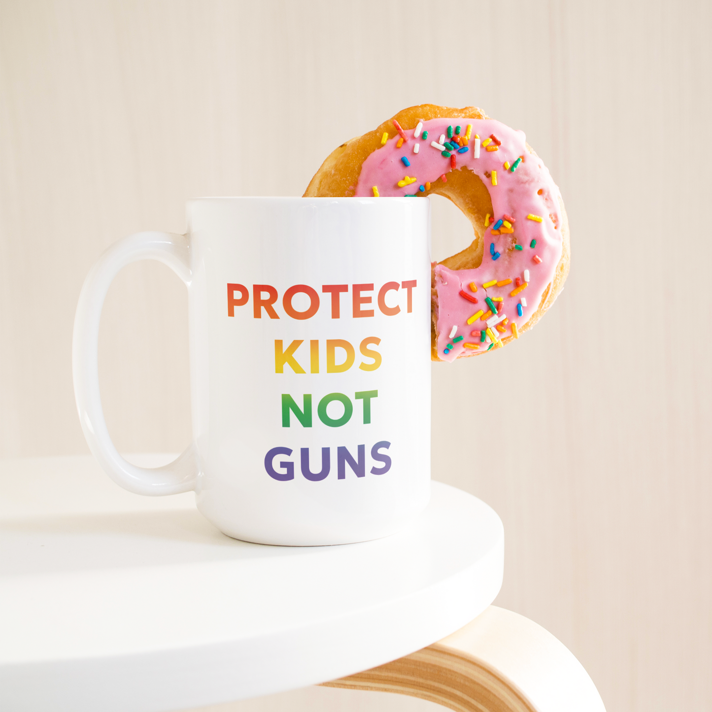 Rainbow_Ombre_Mug_with_Quote_Protect_Ki_15ozWhiteMugLifetsyleDonutLH_Mockup.png
