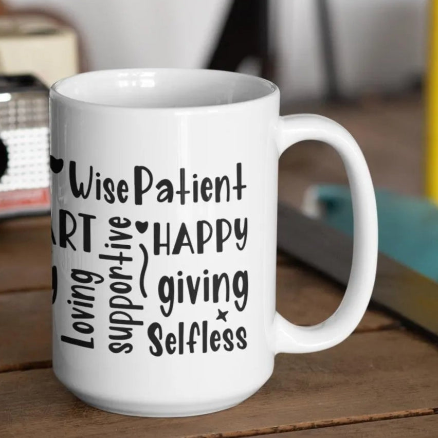 White ceramic coffee mug covered in bold, hand-lettered black typography featuring uplifting words that describe mothers, such as “BRAVE,” “SMART,” “LOVING,” “STRONG,” “HAPPY,” “PATIENT,” and more. The design wraps around the entire mug, creating a vibrant, heartfelt word cloud tribute to mom. Displayed in a triple view, showcasing all angles of the print. Perfect for Mother's Day, birthdays, or just to show appreciation. A thoughtful and inspiring gift for any mom.