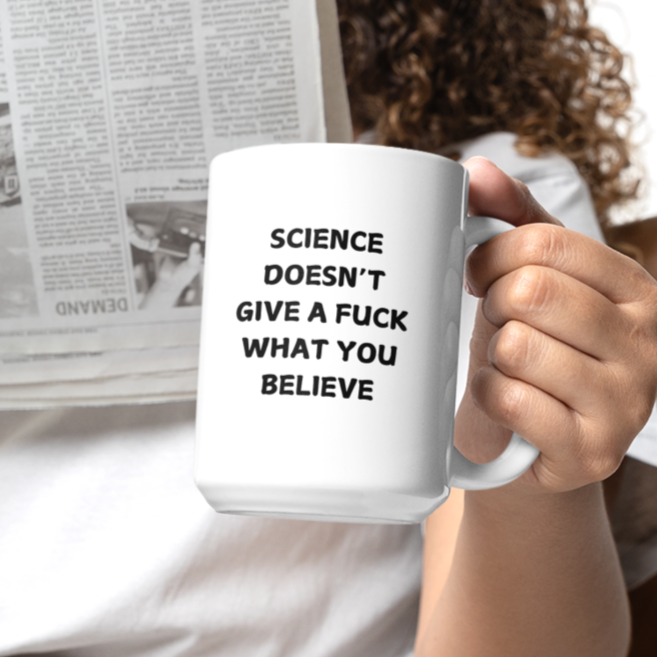 15 oz white ceramic coffee mug featuring bold black text that reads, "SCIENCE DOESN'T GIVE A F*CK WHAT YOU BELIEVE." The design uses an all-caps, sans-serif font with a slightly playful, bold look. Ideal for science enthusiasts, skeptics, and anyone who appreciates blunt humor with a dose of scientific truth.