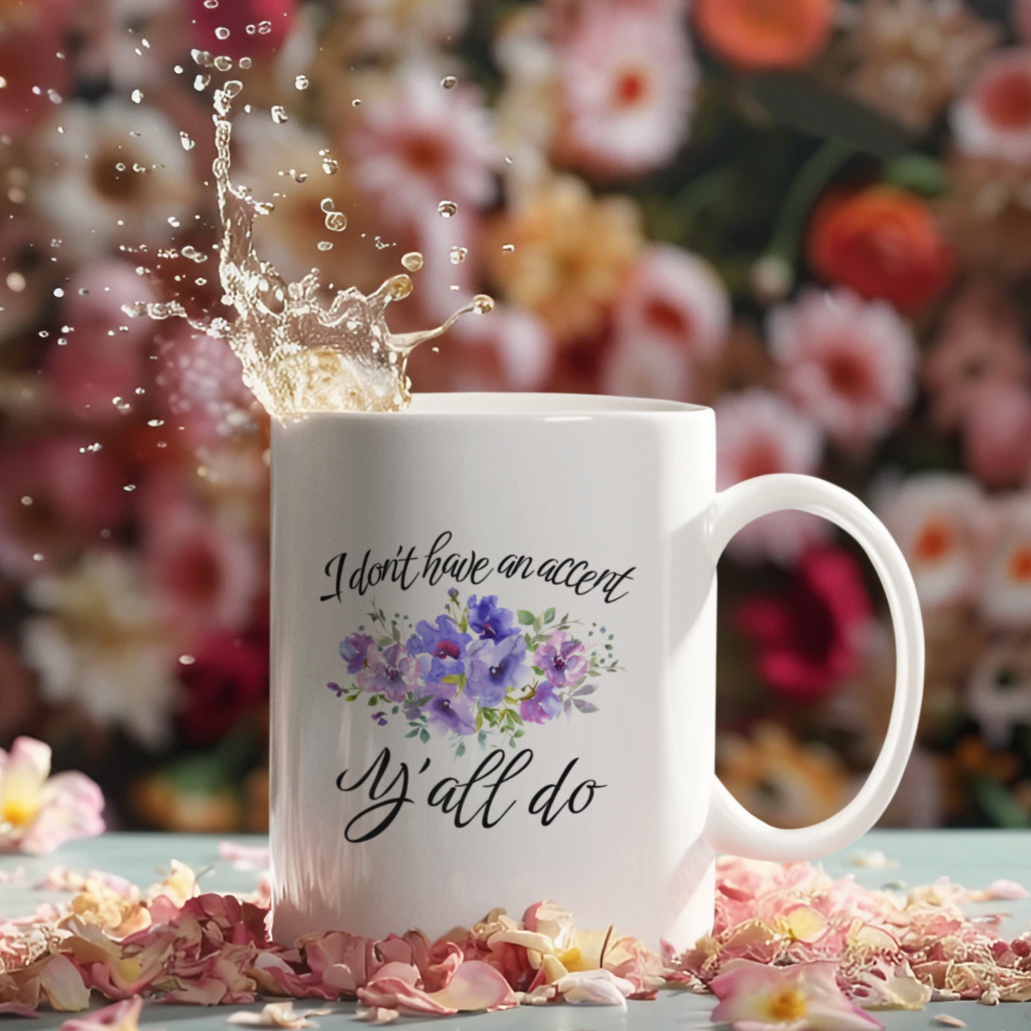 11 oz White ceramic coffee mug featuring a charming, southern-inspired design. The front showcases a whimsical quote in elegant, black cursive font that reads, “I don’t have an accent, Y’all do.” Between the two lines of text, there’s a delicate watercolor illustration of purple and lavender flowers with green foliage, adding a soft, feminine touch.