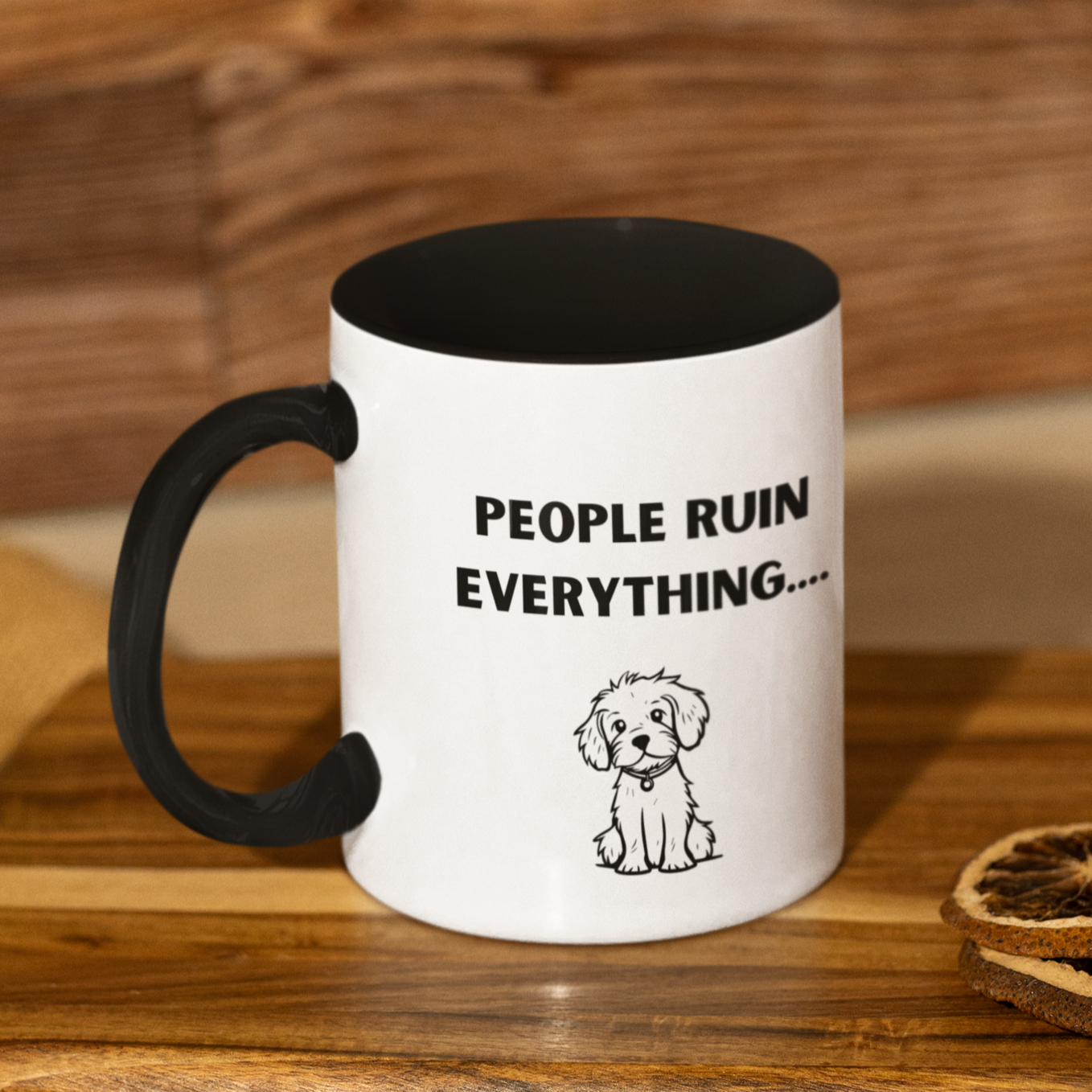 11 oz ceramic coffee mug featuring a humorous and relatable design. The exterior is glossy white with a black handle and black interior for a sleek, modern contrast. Printed on the front is the phrase "PEOPLE RUIN EVERYTHING...." in bold, playful black font. Below the text is an adorable illustration of a small, scruffy dog with a sweet, innocent expression, adding charm and humor to the message.