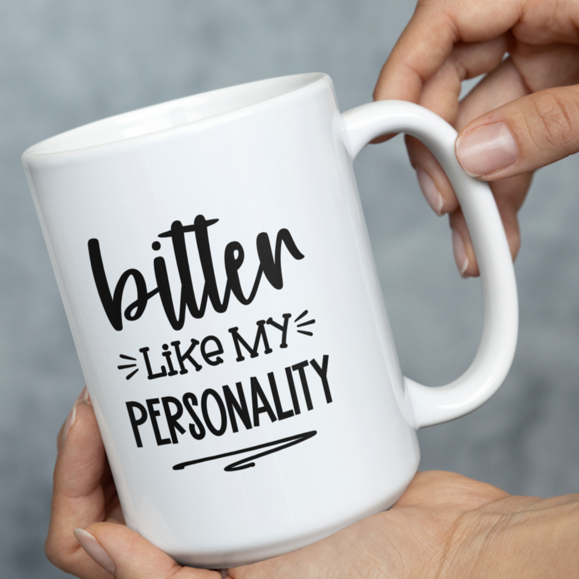 Humorous 15 oz white ceramic mug held in two hands. Black text reads "bitter LIKE MY PERSONALITY" in a playful, slightly sarcastic font. Perfect for those with a dry wit and a love for coffee or tea. Makes a funny gift for friends, family, or coworkers who appreciate dark humor.