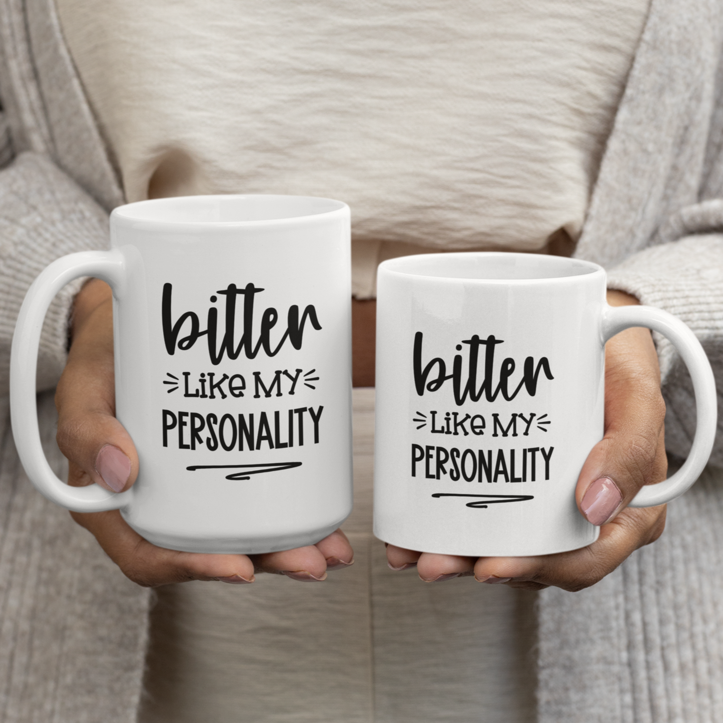 Humorous 11 & 15 oz white ceramic mug held in two hands. Black text reads "bitter LIKE MY PERSONALITY" in a playful, slightly sarcastic font. Perfect for those with a dry wit and a love for coffee or tea. Makes a funny gift for friends, family, or coworkers who appreciate dark humor.