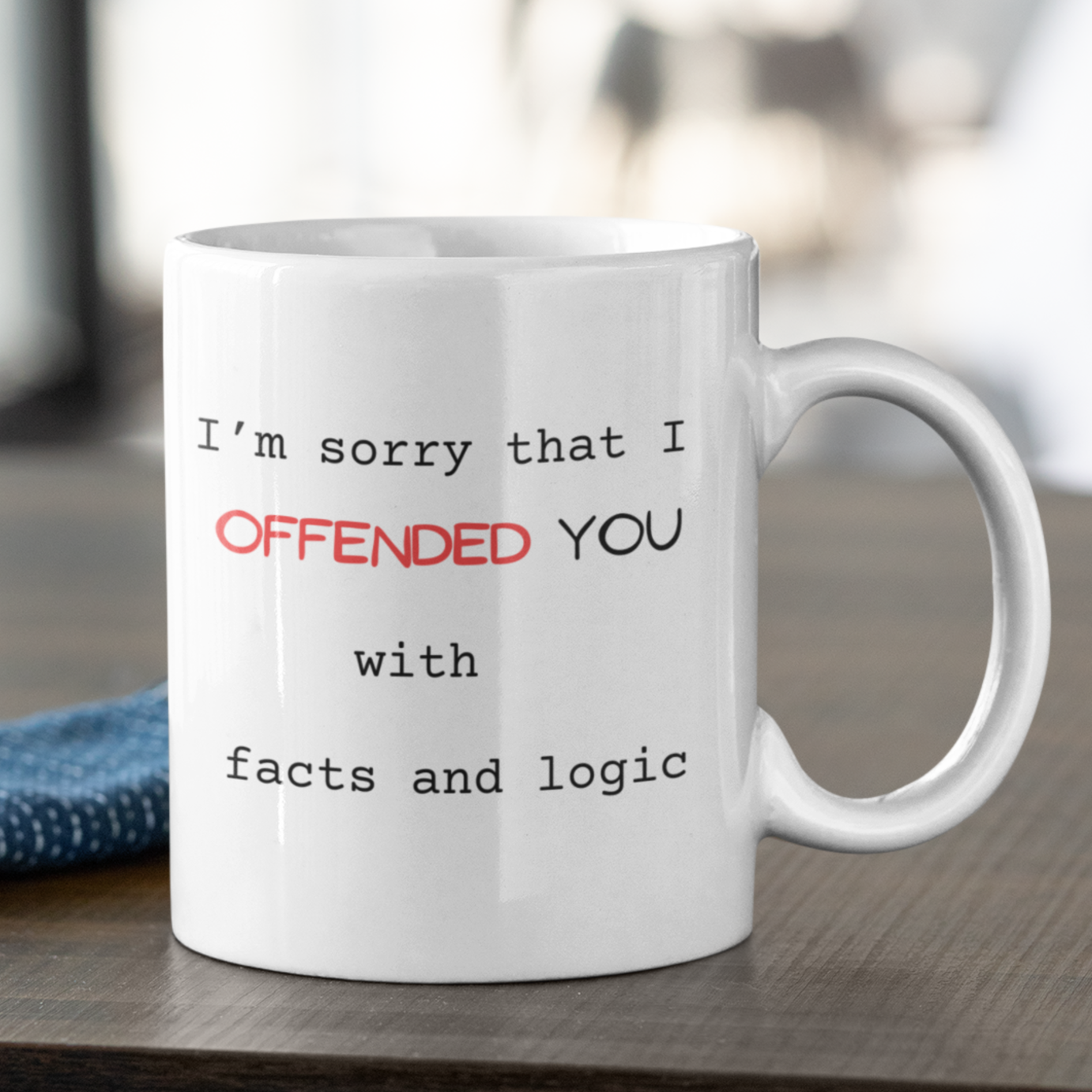 11 oz White ceramic coffee mug featuring a humorous and sarcastic printed message perfect for office settings or gifting to friends with a witty sense of humor. The text reads: "I’m sorry that I OFFENDED YOU with facts and logic." The word "OFFENDED" is highlighted in bold red uppercase letters for emphasis, while the rest of the message is in a simple, black typewriter-style font. Large handle for easy grip. Ideal novelty gift for coworkers, debaters, and logic lovers.