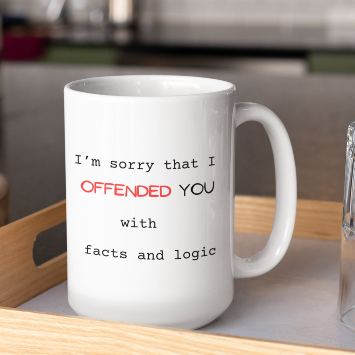 15 oz White ceramic coffee mug featuring a humorous and sarcastic printed message perfect for office settings or gifting to friends with a witty sense of humor. The text reads: "I’m sorry that I OFFENDED YOU with facts and logic." The word "OFFENDED" is highlighted in bold red uppercase letters for emphasis, while the rest of the message is in a simple, black typewriter-style font. Large handle for easy grip. Ideal novelty gift for coworkers, debaters, and logic lovers.