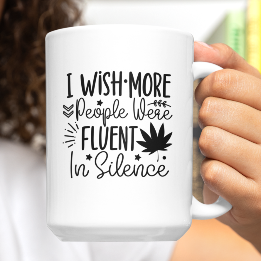Stylish white ceramic mug with a sassy black text design that reads, “I wish more people were fluent in silence,” accented with playful stars, leaves, and a bold graphic of a maple leaf. Minimalist aesthetic—perfect for introverts, deep thinkers, or anyone who values peace and quiet. Durable, dishwasher-safe, and great for gifting or personal use with hot beverages like coffee or tea.