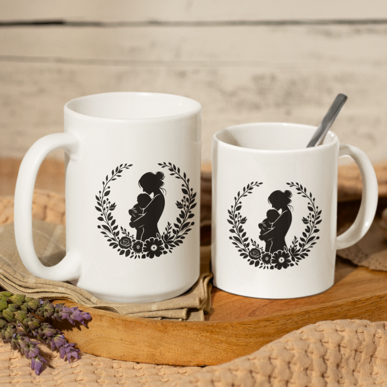 Charming white ceramic mug featuring a tender black silhouette of a mother cradling her baby, framed by a delicate floral wreath. This mug radiates love and comfort. Ideal for gifting to new moms, celebrating Mother’s Day, or honoring the beauty of motherhood. Durable, dishwasher and microwave safe—perfect for everyday coffee, tea, or cocoa moments.