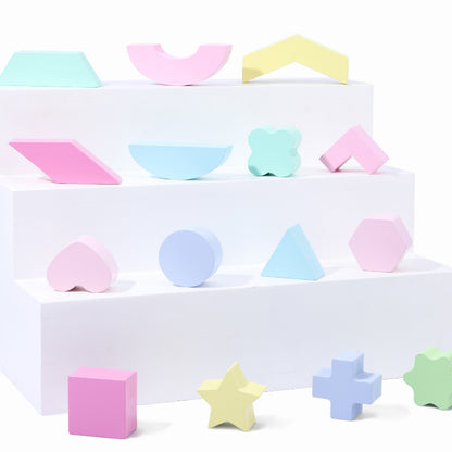 15 pastel shape blocks on display in white shelving. all different shapes
