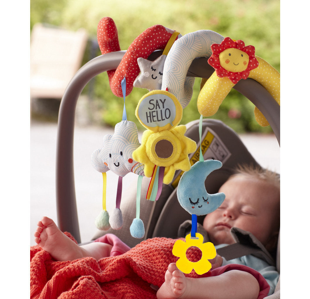 infant in car seat with plush spiral toy wrapped around carrying handle with sunshine and stars, clouds and moon with patchwork of fabric on the spiral