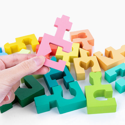 disassembled puzzle pictured with adult hand holding up one piece to demonstrate scale