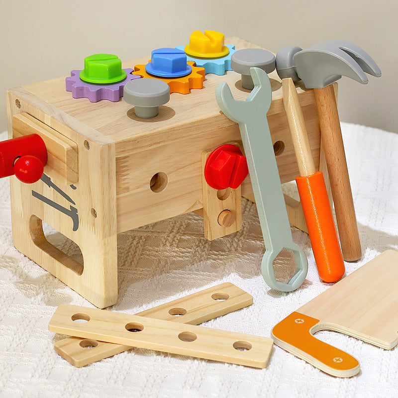toy tool box turned over to be used as a tiny tool bench. shown with all of the accessories, including gears, screws, wrench, screwdriver, hammer and saw