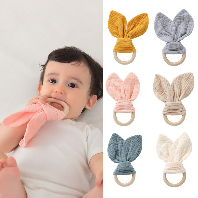 infant chewing on teething ring on one side and 6 teething rings on other