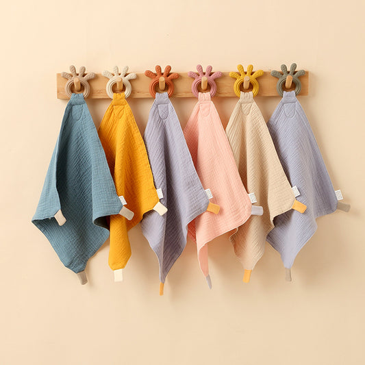 multiple color teething towels hanging on a coat rack