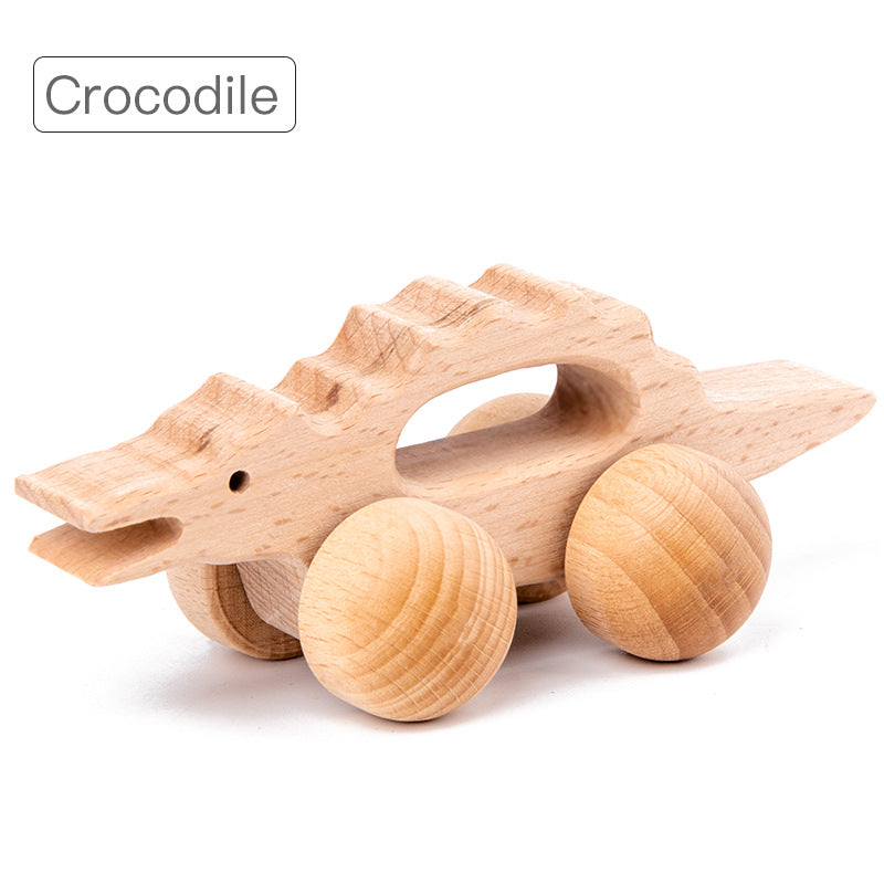 crocodile rolling animal toy with natural wood and large round wheels. opening in center of toy for gripping