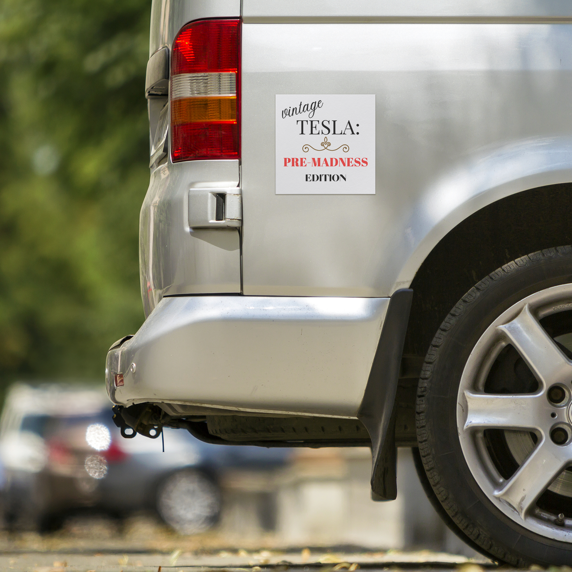 Car magnet design featuring elegant typography with the phrase 'Vintage TESLA: PRE-MADNESS EDITION'. The word 'vintage' is in a stylish cursive black font, 'TESLA:' in bold serif black, and 'PRE-MADNESS' in striking bold red capitals, drawing attention. Below is 'EDITION' in black block letters. A gold ornamental flourish adds a classy vintage touch. Perfect for Tesla enthusiasts who appreciate its legacy before modern chaos!