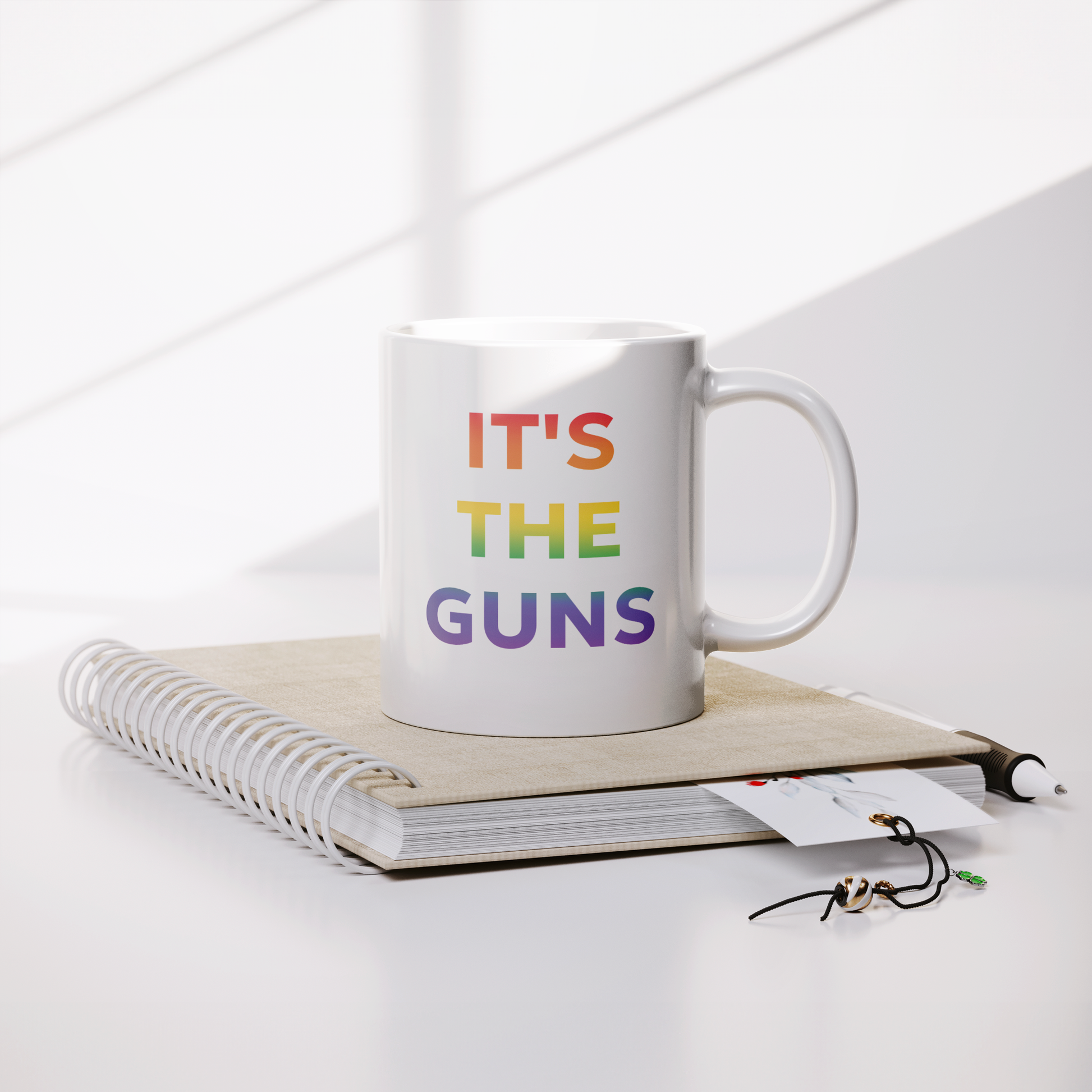 Its_The_Guns_Coffee_Mug_Supporting_Gun__Lifestyle_Notebook_Mockup.png