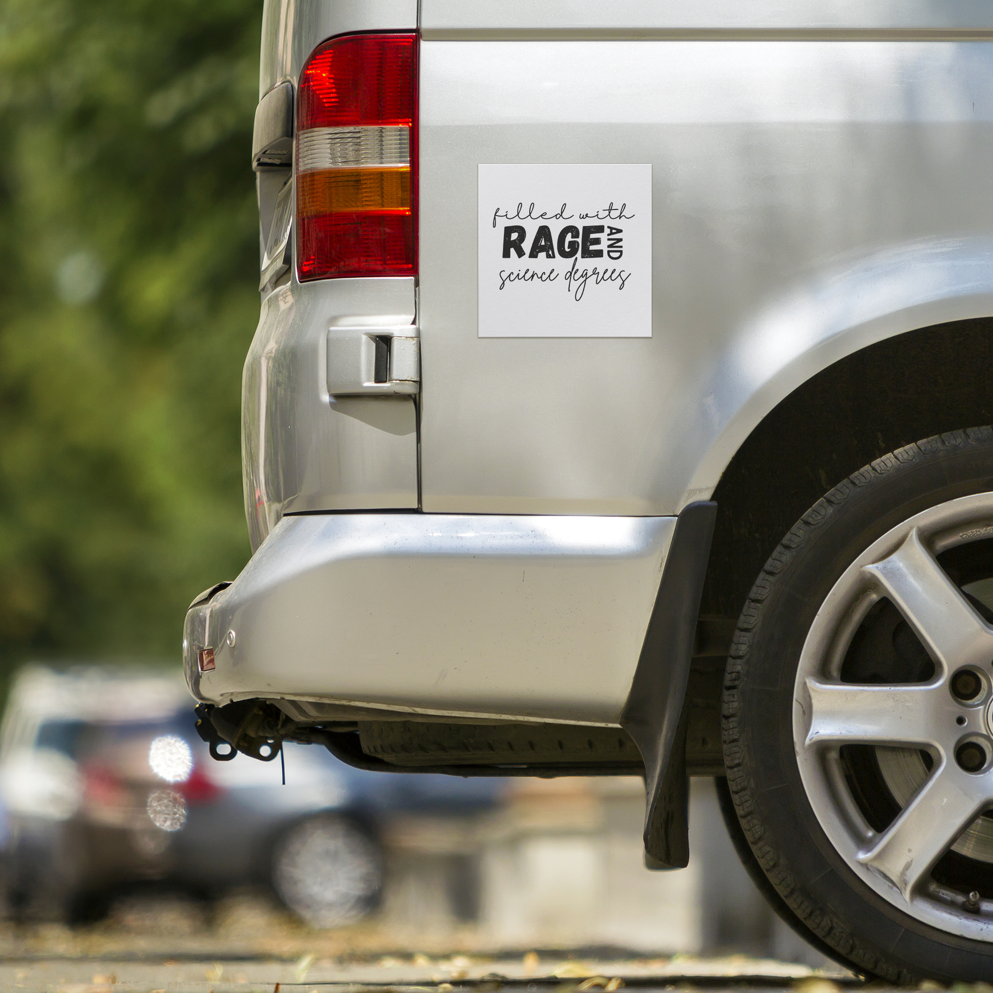 A white square magnet with a bold, empowering message: “filled with RAGE AND science degrees.” The word “RAGE” stands out in large, distressed block letters, while the rest of the text uses elegant, cursive script for contrast. “AND” is rotated vertically next to “RAGE.” Perfect for scientists, students, or professionals who combine intellect with passion. Adds a fierce, witty touch to any fridge, office, or lab space.