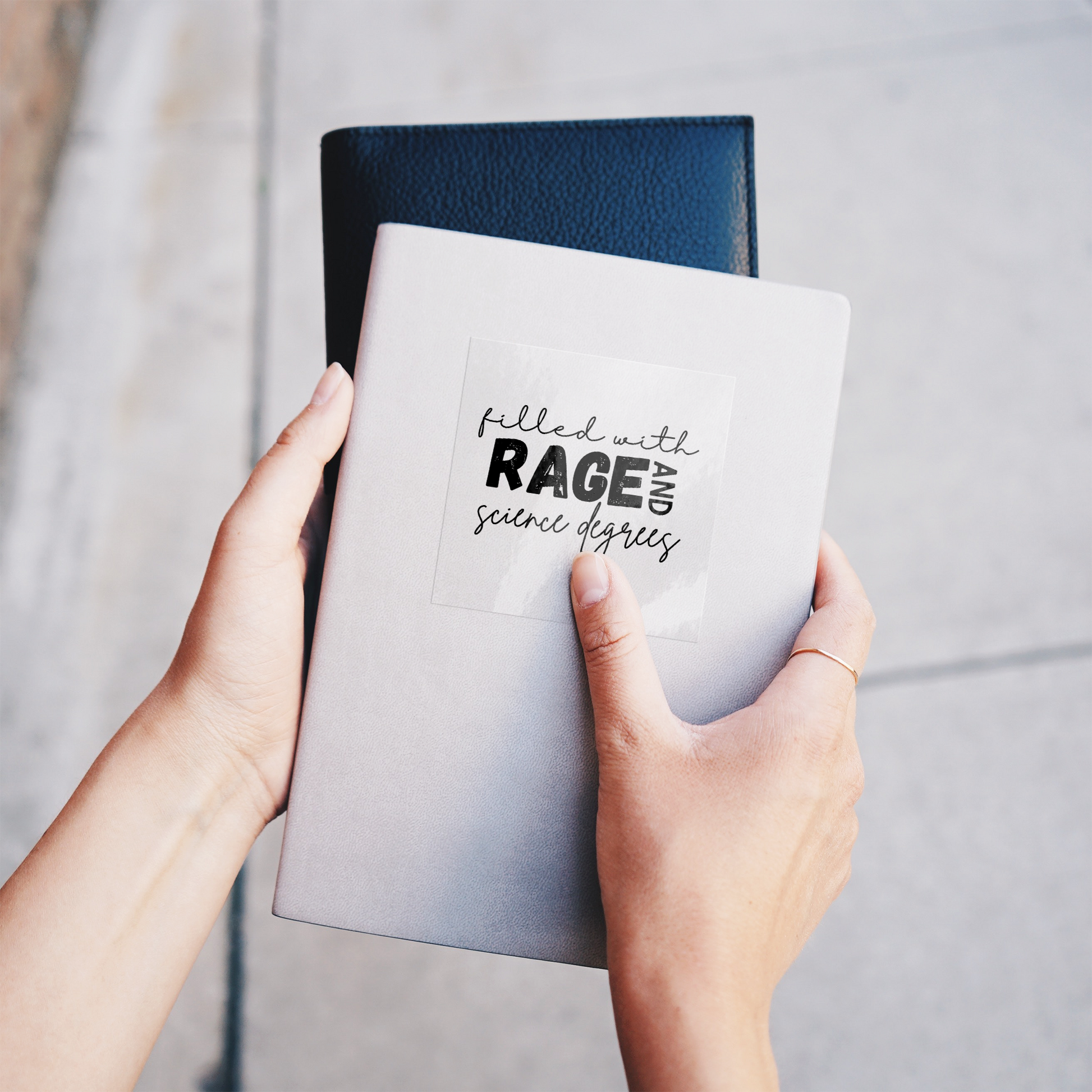 Sticker design featuring a bold, empowering quote: “Filled with RAGE and science degrees.” The word “RAGE” is in all caps, distressed block letters for a dramatic, rebellious feel, while the rest of the phrase is in an elegant, handwritten script that contrasts with the boldness. Perfect for laptops, water bottles, or notebooks—ideal for scientists, students, feminists, and activists who embrace both intellect and passion. Matte finish, durable vinyl.