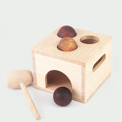 Pictured is the natural wood knock box with 3 holes in the top and natural wood mallet and 3 dark wood balls