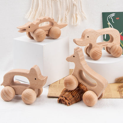 image of 4 rolling wooden animal toys on display, including rhino, elephant, horse and alligator. Each item is natural wood and has large round wheels