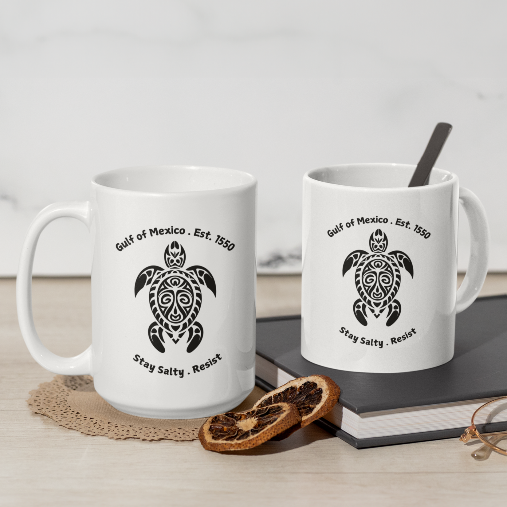 11 and 15 oz High-quality ceramic coffee mug featuring a bold, tribal-style sea turtle graphic in black. The design showcases the text “Gulf of Mexico • Est. 1550” above the turtle and “Stay Salty • Resist” below, giving it a coastal, eco-conscious vibe. The mug is finished in a glossy white glaze with a comfortable, large curved handle for easy grip. Ideal for ocean lovers, environmental advocates, or anyone who appreciates unique, artistic drinkware with a message of resilience and coastal pride.